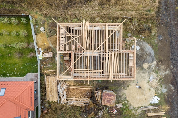 Cima para baixo vista aérea de uma casa em construção com estrutura de telhado de madeira.