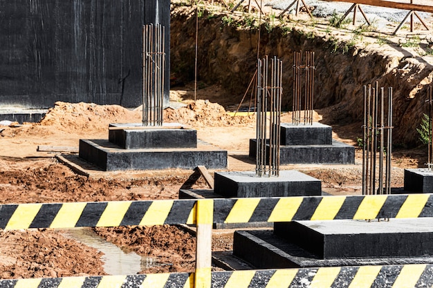 Foto cimentaciones monolíticas de hormigón armado para la construcción de un edificio residencial. parrilla en el sitio de construcción. pozo de construcción con cimientos.