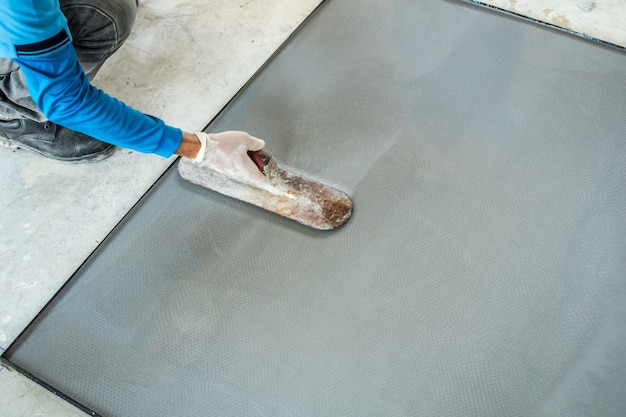 Foto cimento de terrazzo de emplastro com o trabalhador no molde