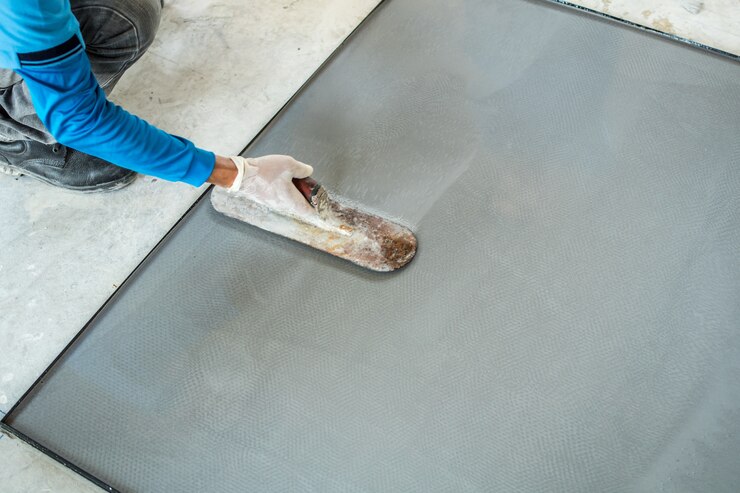Cimento de terrazzo de emplastro com o trabalhador no molde