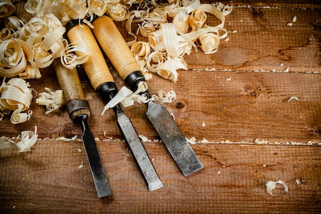 Cinceles con virutas de madera sobre un fondo de madera