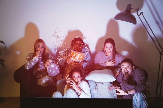 Foto cinco amigos viendo una película juntos