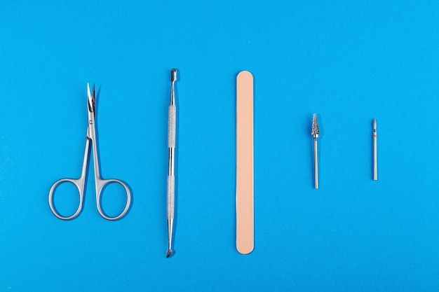 Cinco ferramentas de manicure em um fundo azul