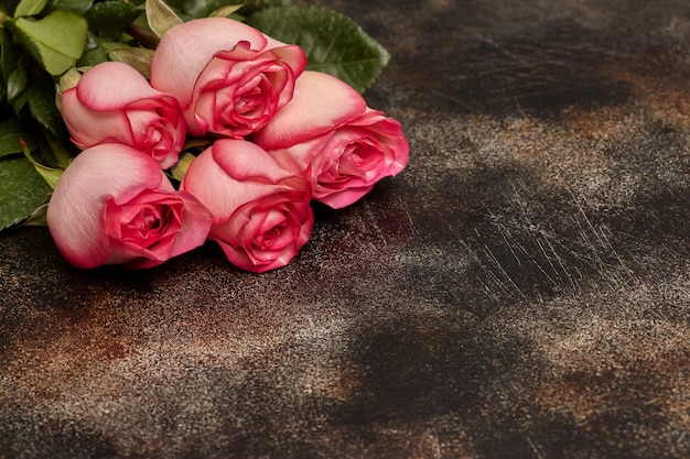 Cinco hermosas rosas rosadas en marrón