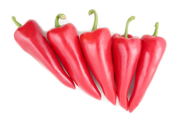 Los cinco pimientos rojos brillantes sobre un fondo blanco. comida y verduras frescas saludables