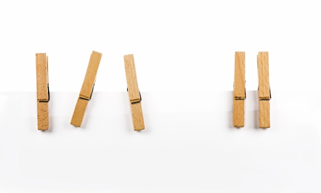 Cinco pinzas de madera en una cuerda aislada en blanco