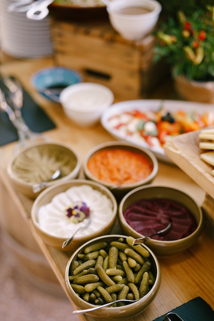 Cinco platos de comida para un banquete en la mesa con un aperitivo de tomate