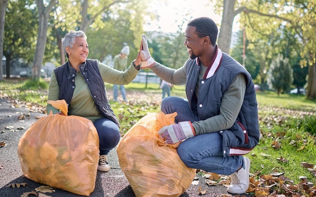 Los cinco voluntarios o el equipo celebran la limpieza de los productos de desecho de la contaminación de la basura o el apoyo al medio ambiente Contenedor de bolsas de plástico Ayuda benéfica de la ONG o comunidad ecológica hecha con la limpieza de la naturaleza