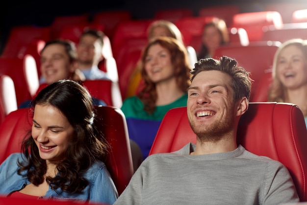 cine, entretenimiento y concepto de personas - amigos felices viendo películas de comedia en el teatro