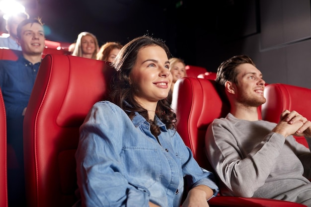 cine, entretenimiento y concepto de personas - amigos felices viendo películas de comedia en el teatro