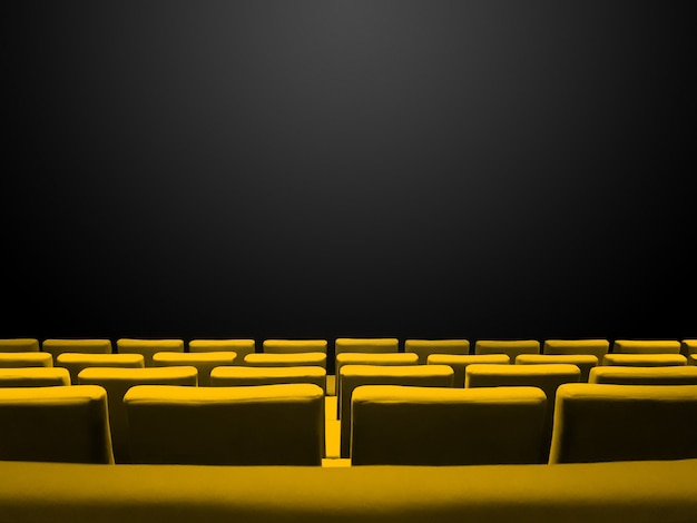 Cine sala de cine con filas de asientos amarillos y un fondo negro del espacio de la copia