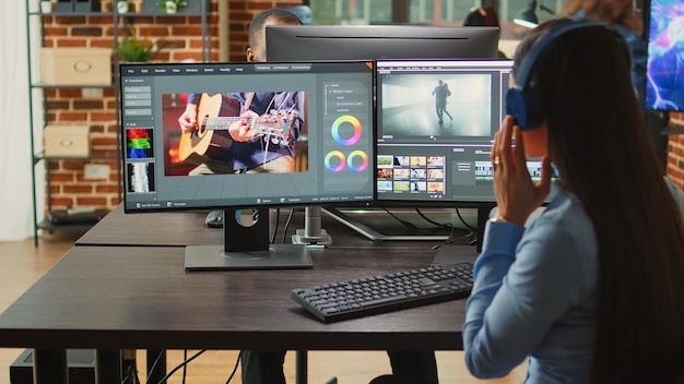 Cineasta asiático editando montaje de video y audio en la oficina de la agencia creativa, usando iluminación y edición de enfoque en el estudio. Mujer independiente que trabaja con el diseño de imágenes de películas en software de videografía.