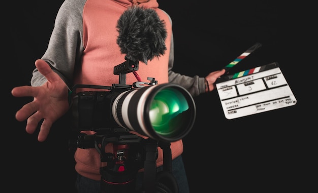 Cineasta o director de fotografía que usa equipo de cámara profesional para hacer documentales y películas. Conceptos de joven camarógrafo, audiovisual, cuentacuentos y dirección de cine.