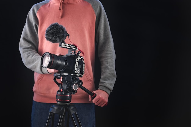 Cineasta o director de fotografía que usa equipo de cámara profesional para hacer documentales y películas. Conceptos de joven camarógrafo, audiovisual, cuentacuentos y dirección de cine.