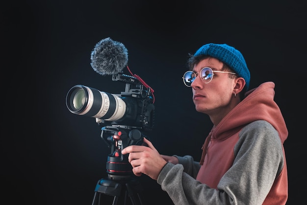 Cineasta o director de fotografía que usa equipo de cámara profesional para hacer documentales y películas. Conceptos de joven camarógrafo, audiovisual, cuentacuentos y dirección de cine.