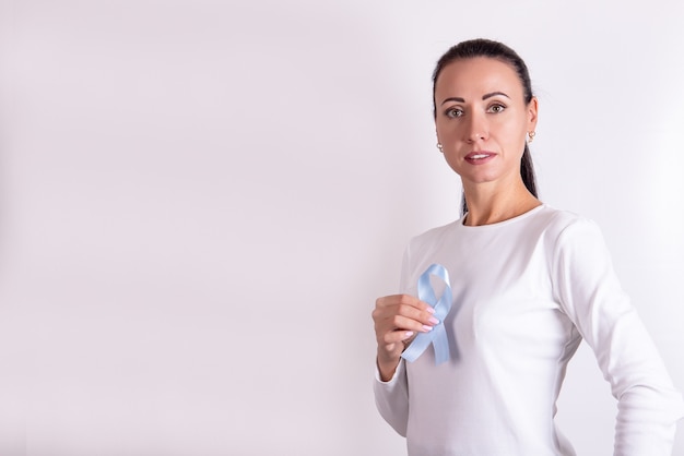 Foto la cinta azul en una mano femenina simboliza la conciencia del cáncer de próstata y la salud de los hombres