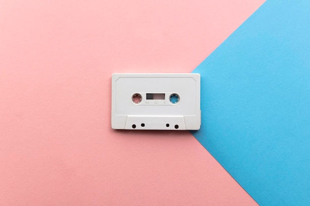 cinta de cassette blanca vintage sobre un fondo azul y rosa.