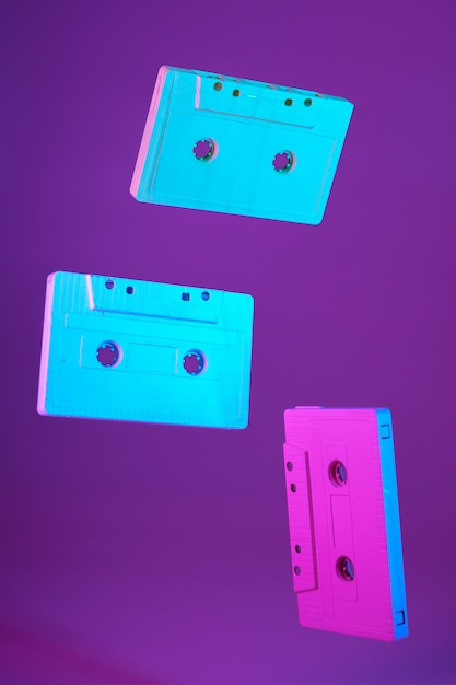 Cinta de cassette estilo vintage suspendido en el aire sobre fondo morado