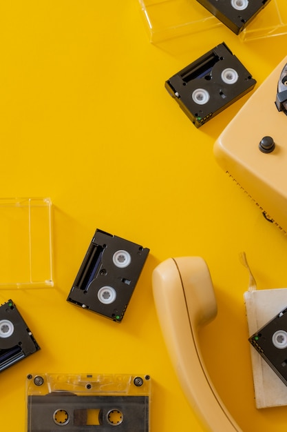 Cinta de cassette negro retro fondo amarillo antiguo teléfono auricular vista superior copia espacio
