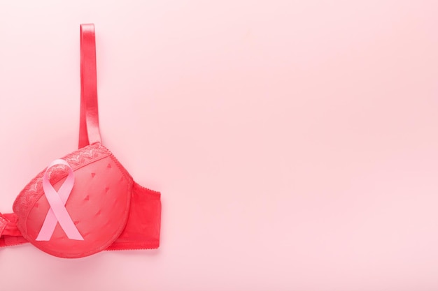 Cinta de concientización sobre el cáncer de mama Sujetador rojo y cinta de cinta rosa sobre un sostén femenino sobre fondos Concienciación sobre el cáncer de mama y Día mundial del cáncer de octubre Día rosa Vista superior Mock up