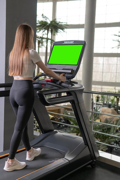 Cinta de correr de mujer en el interior de longitud perfil joven personas activas completas para entrenamiento en forma desde el cuerpo