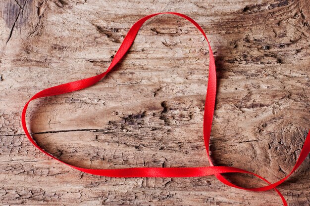 Cinta en forma de corazón sobre fondo de madera