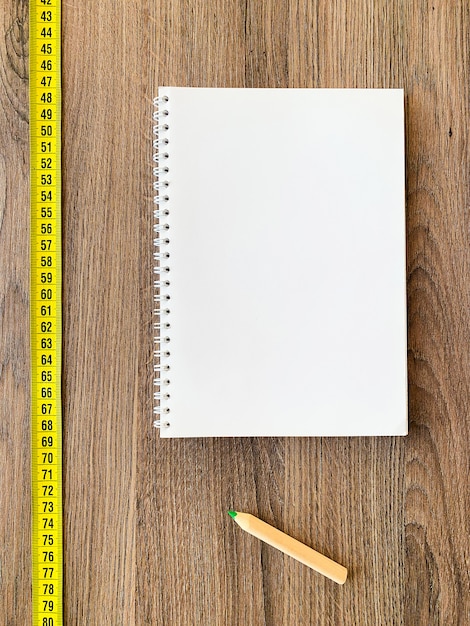 Foto cinta métrica en madera con libreta de diario y bolígrafo para una buena forma física