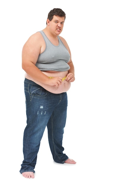 Foto cinta métrica de obesidad en el abdomen y el retrato de un hombre enojado que verifica la salud del cuerpo y aislado en el fondo blanco hombre frustrado que mide el progreso de la pérdida de peso y el estómago en el fondo del estudio