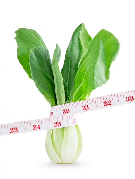 La cinta métrica que envuelve la verdura pierde concepto del peso aislada en blanco