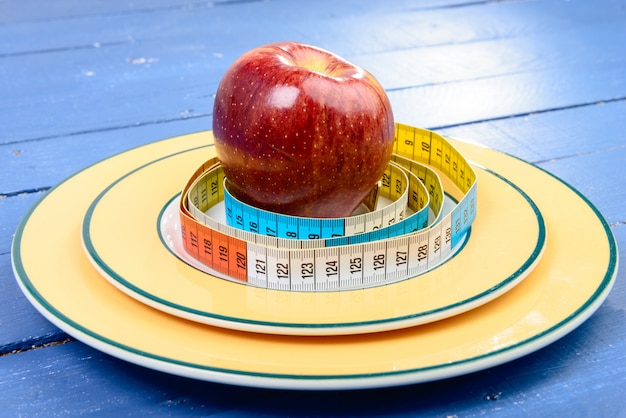 Cinta de un metro alrededor de manzana en el plato