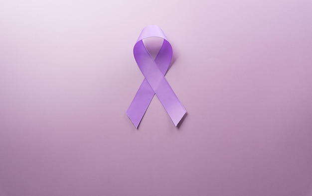 Cinta morada sobre fondo de papel pastel para apoyar la campaña del Día Mundial contra el Cáncer el 4 de febrero