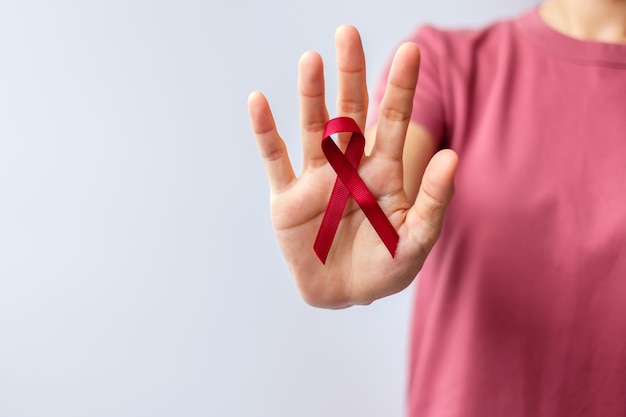 Cinta roja de Borgoña para el cáncer de mieloma múltiple de marzo y el mes de concientización del Día Mundial del SIDA de diciembre Concepto de atención médica y día mundial del cáncer