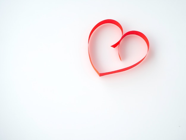 Cinta roja en forma de corazón sobre un fondo blanco.