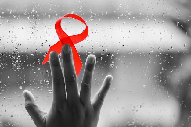 Foto cinta roja en las manos para el fondo de la campaña contra el sida y el cáncer