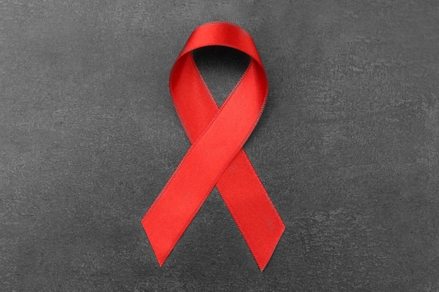Cinta roja sobre fondo gris concepto de sida
