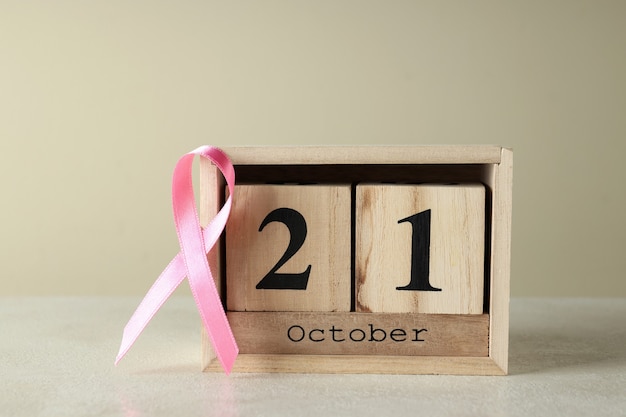 Cinta rosa de concienciación y calendario de madera con 21 de octubre.