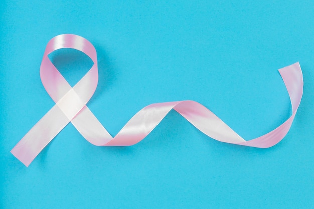 Foto cinta rosa para la concientización sobre el cáncer de mama sobre fondo azul.