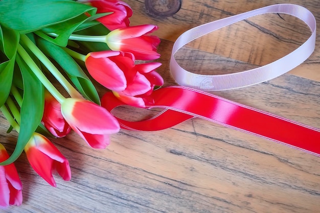 Una cinta rosa está atada a un ramo de flores.