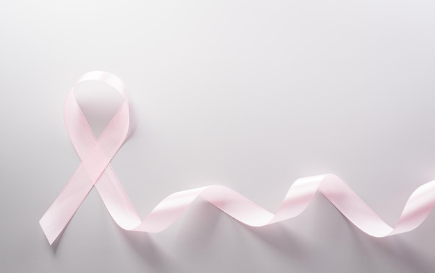 Cinta rosa sobre fondo de papel pastel para apoyar la campaña del mes de concientización sobre el cáncer de mama