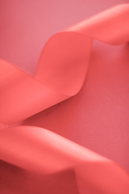 Cinta de seda rizada abstracta sobre fondo de coral diseño exclusivo de marca de lujo para la promoción de productos de venta de vacaciones y el telón de fondo de la tarjeta de invitación de arte glamour