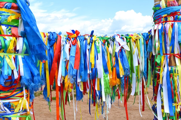 Foto cintas en postes de enganche de la religión del chamanismo en la isla de khuzhir olkhon