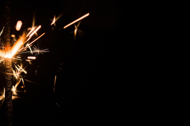 Cintilante ardente em luz amarela e laranja em um fundo preto Foto aproximada de diamante de Natal e ano novo Pode ser usado como papel de parede ou cartão postal