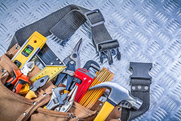 Cinto de ferramentas de couro com objetos de construção no conceito de manutenção de chapas metálicas ranhuradas