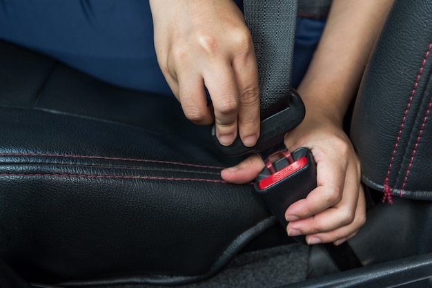 Cinto de segurança. mulher prende o cinto de segurança no carro Condução segura. Cinto de segurança na mão.