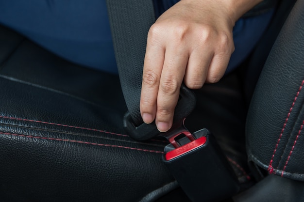 Cinto de segurança. mulher prende o cinto de segurança no carro Condução segura. Cinto de segurança na mão.