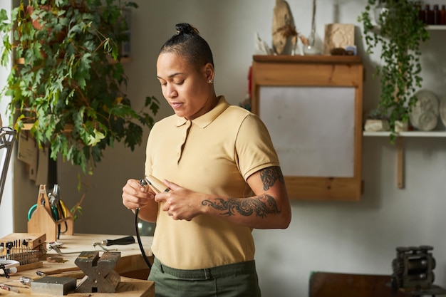 Cintura para arriba retrato de artista femenina multiétnica en taller