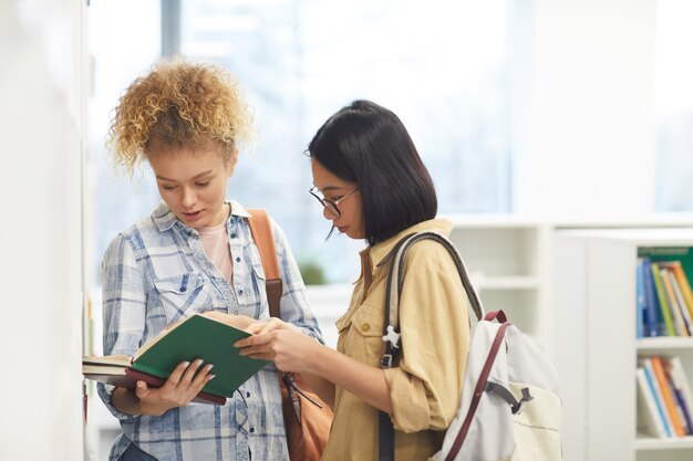 Cintura para arriba retrato de dos estudiantes leyendo libro