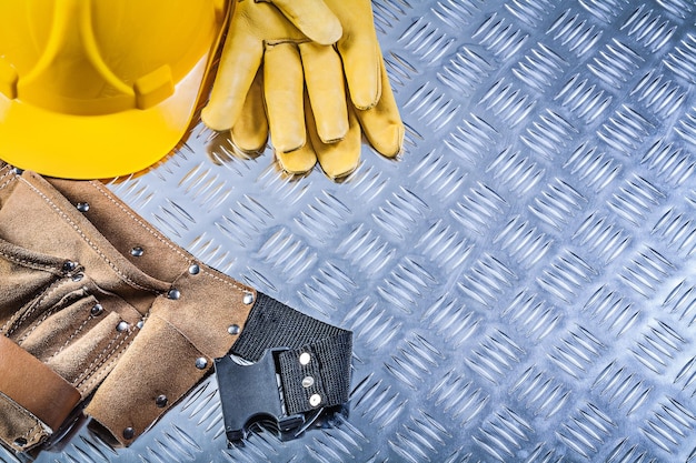 Cinturón de construcción de cuero guantes protectores casco en concepto de construcción de textura de metal corrugado