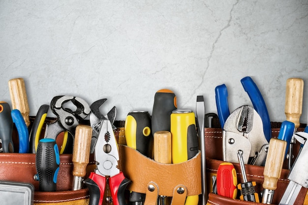 Cinturón de herramientas con herramientas en escritorio de piedra
