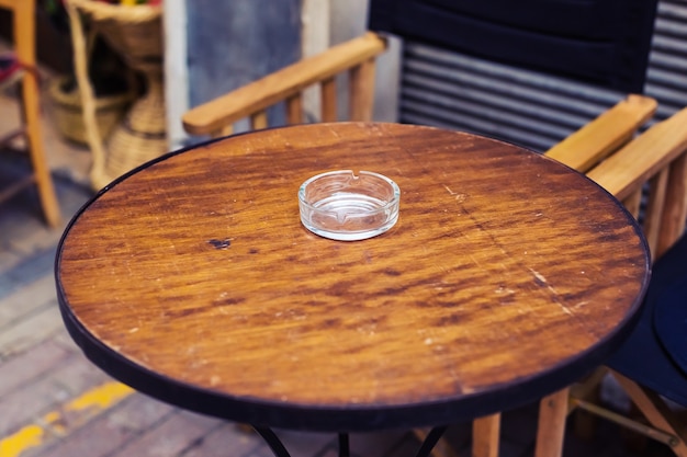 Foto cinzeiro de vidro na mesa de madeira marrom